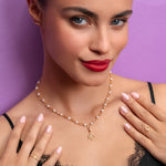 Woman wearing a gold necklace with a purple background