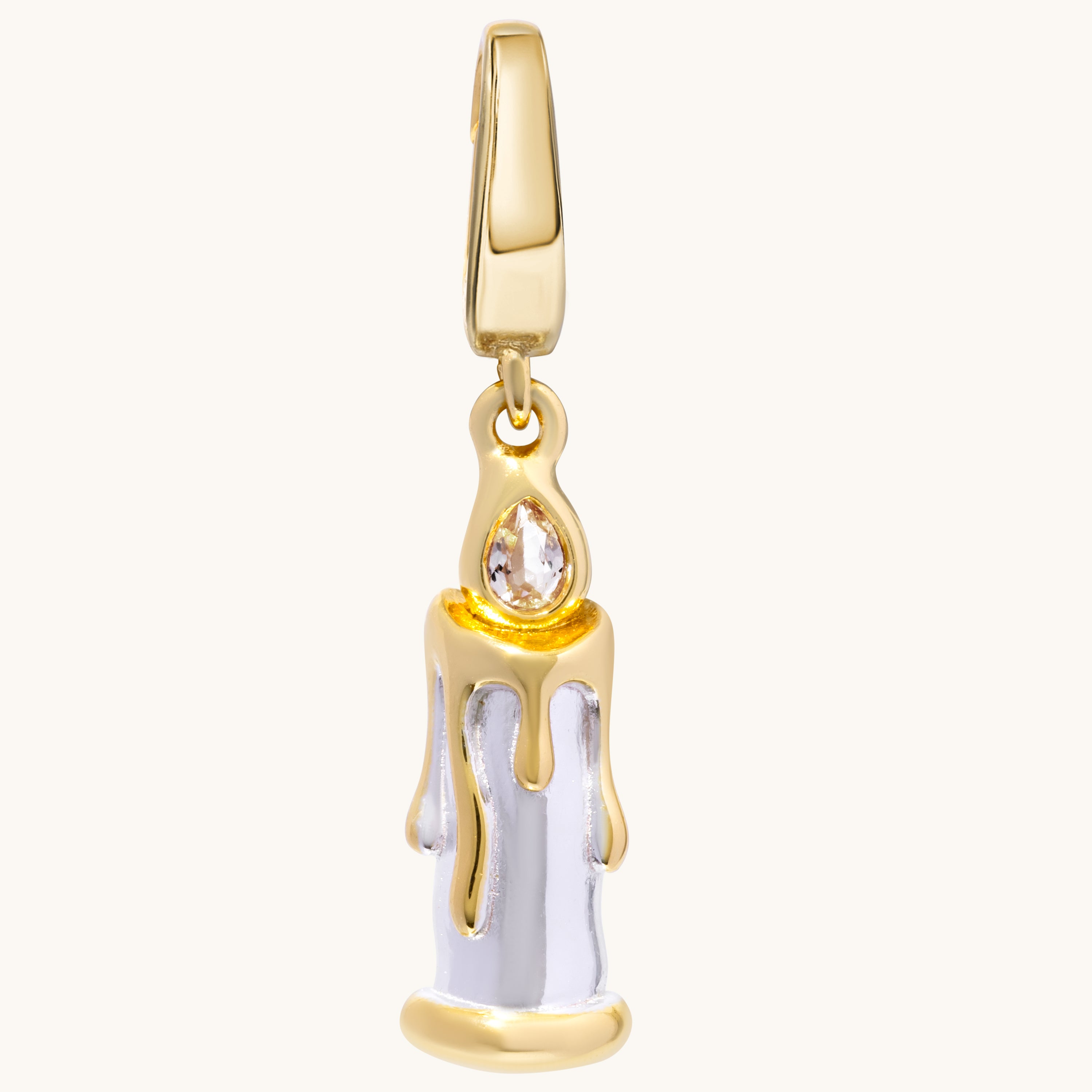 A gold candle charm with sculpted dripping wax and a contrasting metal flame set with a white topaz stone.