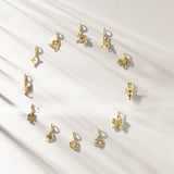 Gold zodiac charms on a white background