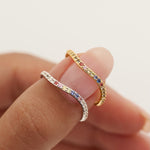 Two rings being worn on a finger against a blurred background