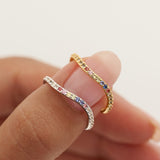 Two rings being worn on a finger against a blurred background