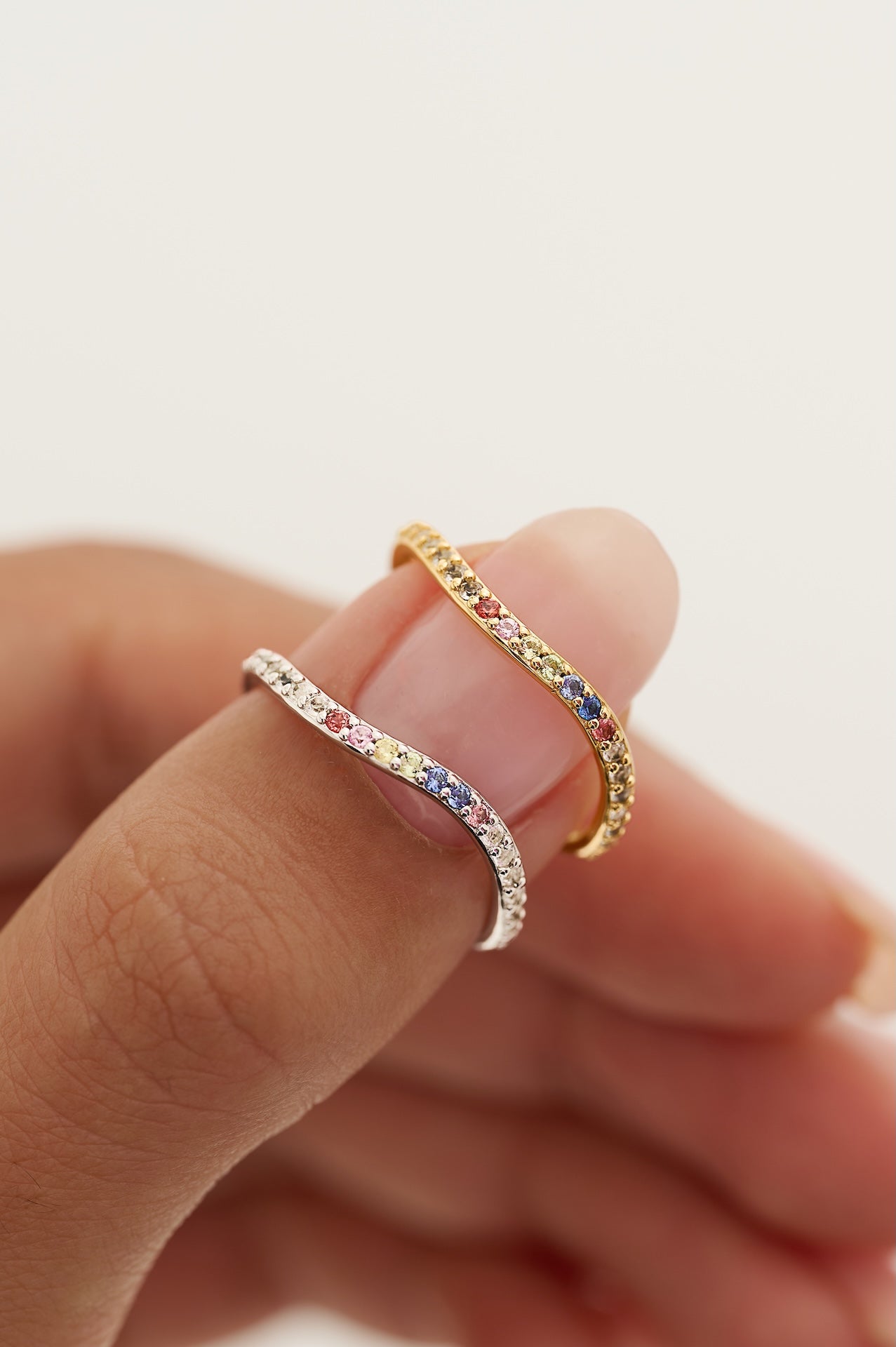 Two rings being worn on a finger against a blurred background