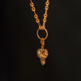 Preorder: Odin Charm (Ships end October 2026)—a gold chain necklace with a textured link and detailed heart pendant featuring two birds, inspired by Norse mythology, shown on a dark background.