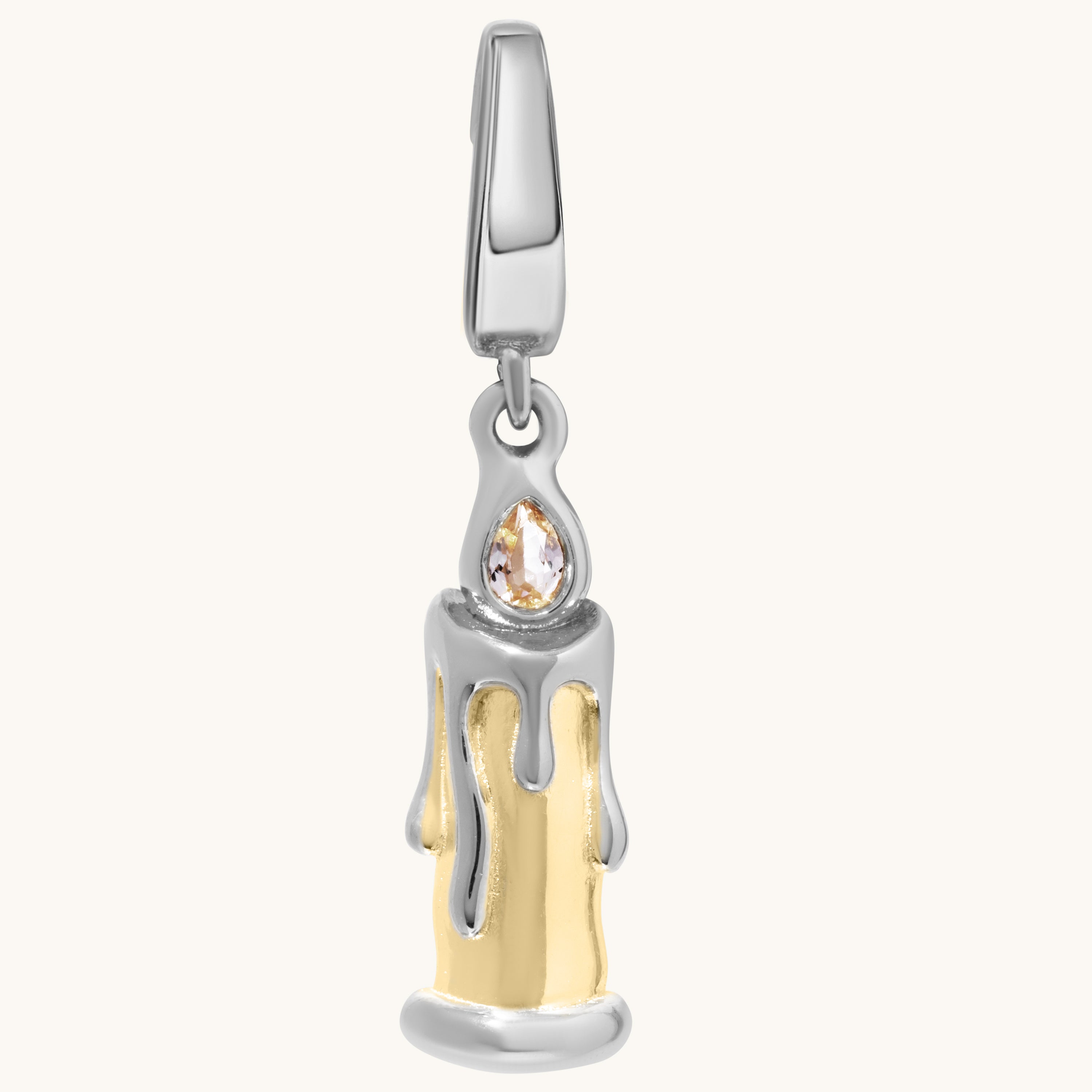 A two-tone silver and gold candle-shaped charm with a clear teardrop gemstone, shown on a light cream background.
