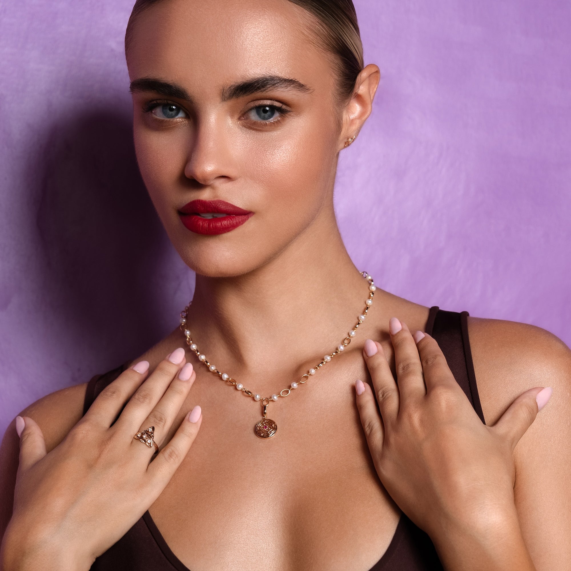 Woman wearing a necklace with a purple background