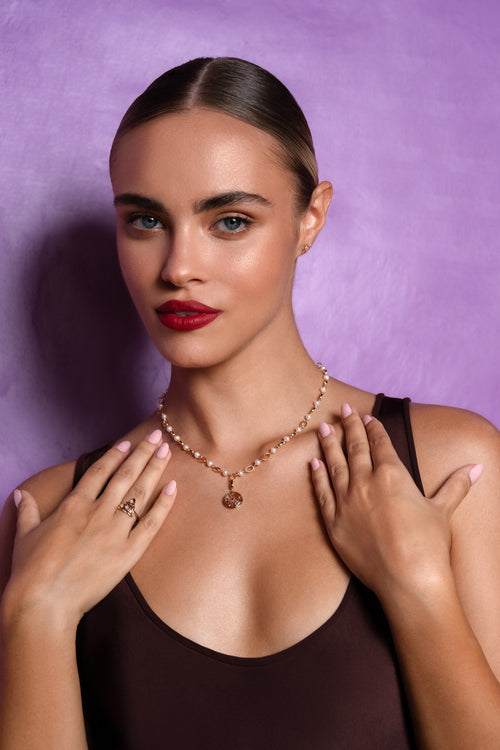 Woman wearing a necklace with a purple background