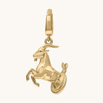 Gold pendant shaped like a goat on a white background