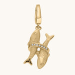 Gold fish-shaped pendant with embedded stones on a white background