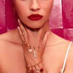 Woman wearing jewelry with a pink background