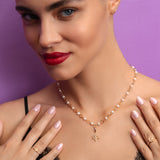 Woman wearing a pearl necklace with a purple background