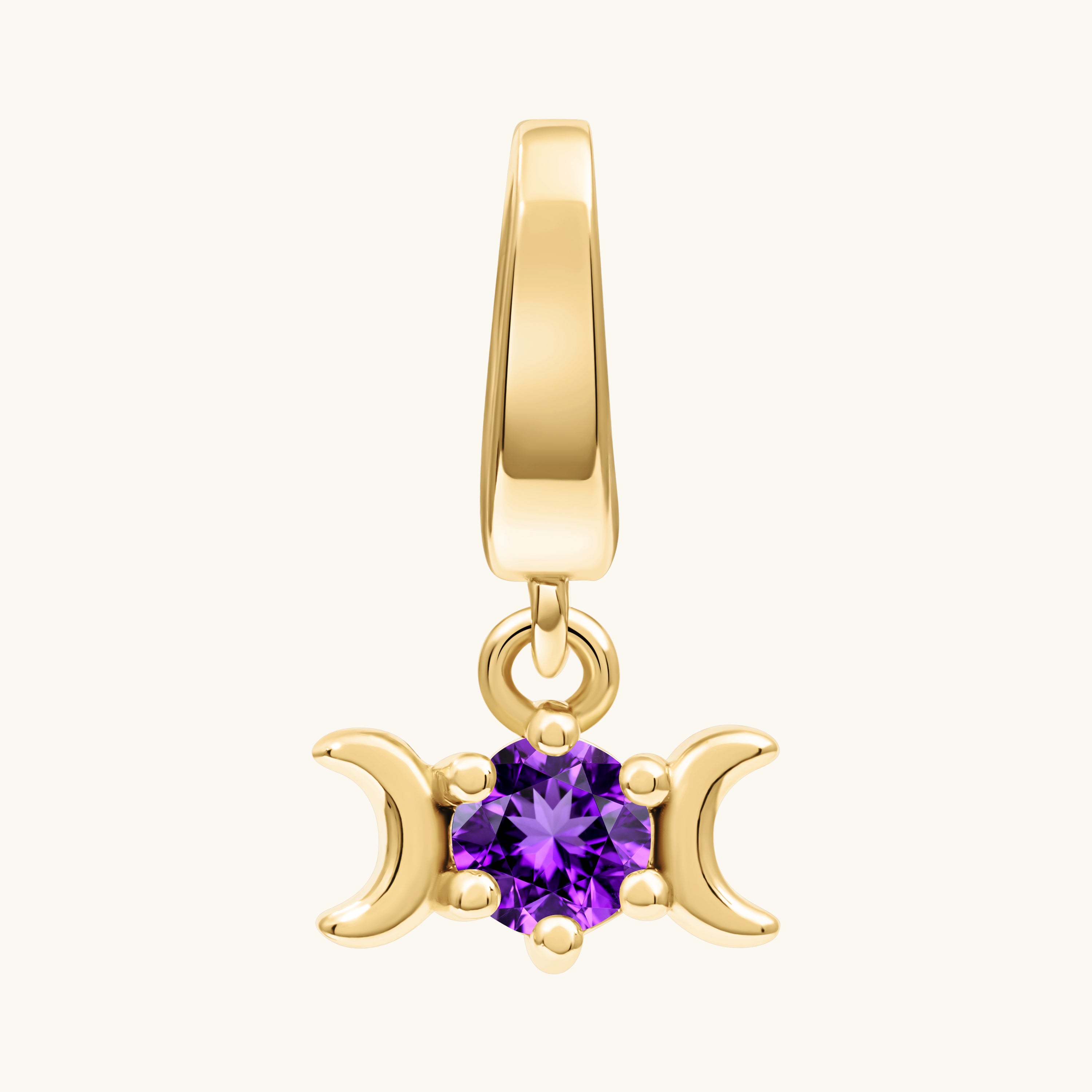 A gold triple moon pendant charm featuring a central round-cut purple amethyst gemstone, set against a plain off-white background.