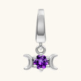 A sterling silver triple moon pendant charm featuring a central round-cut purple gemstone, set against a solid off-white background.