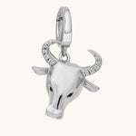 Silver bull head charm with crystal details on a white background