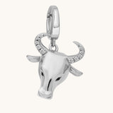 Silver bull head charm with crystal details on a white background