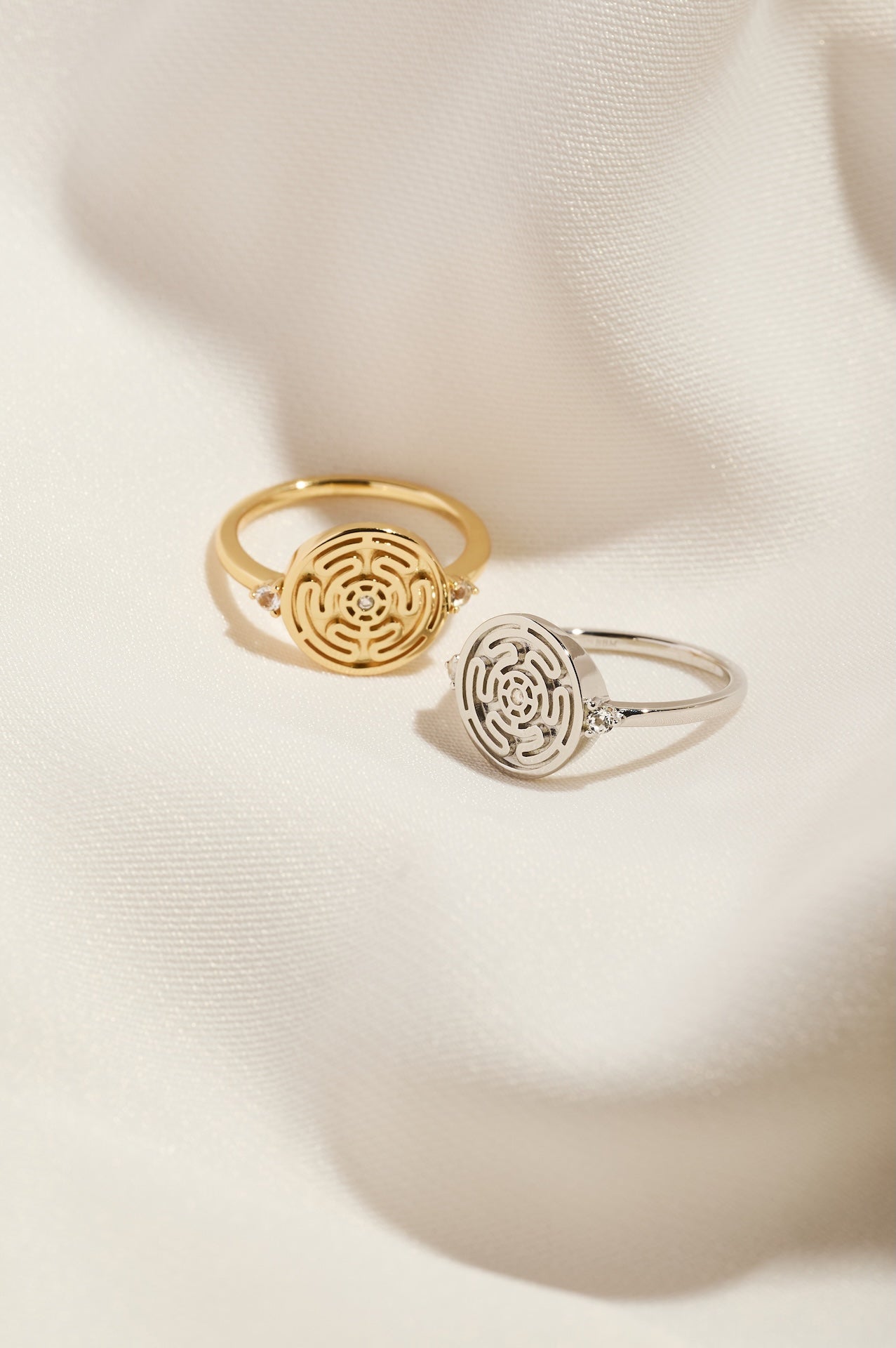 Silver and Gold Hecate's Wheel Rings on Cream Cloth Background