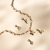 Gold necklace with various zodiac charms on a beige background