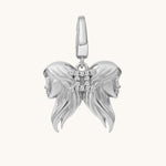 Silver pendant with two female faces on a white background