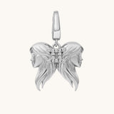 Silver pendant with two female faces on a white background