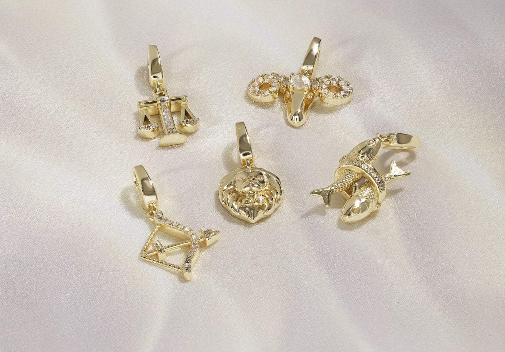 Set of gold zodiac pendants on a white background