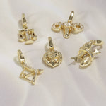 Set of gold zodiac pendants on a white background