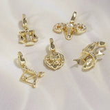 Set of gold zodiac pendants on a white background