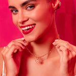 Woman wearing a necklace against a pink background