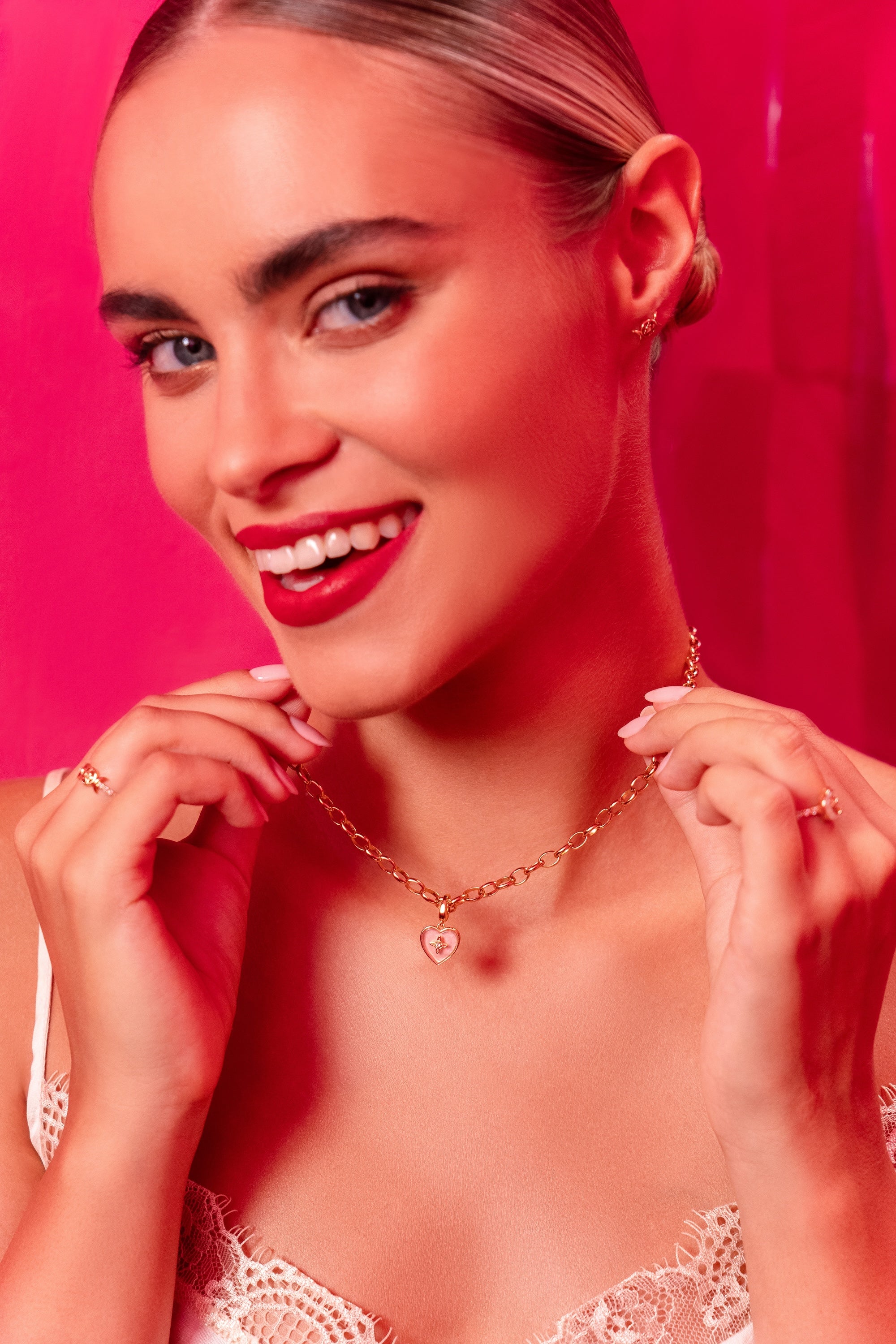Woman wearing a necklace against a pink background