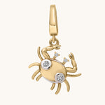 Gold crab-shaped pendant with embedded white topaz stones on a white background