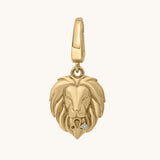 Gold lion head pendant with a white topaz stone on a white background