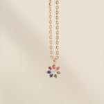 Necklace with a multicolored gemstone pendant on a beige background