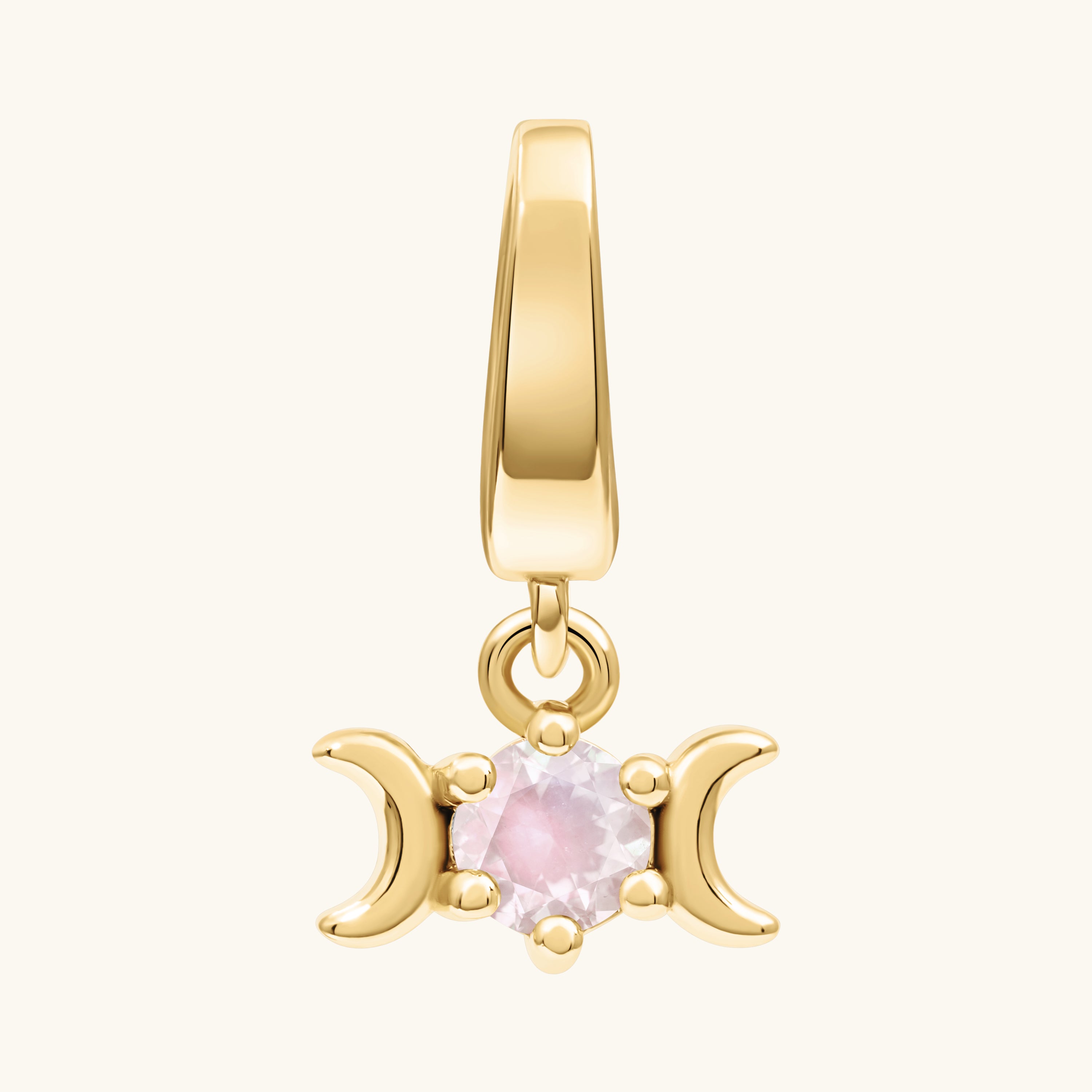 A gold triple moon pendant charm featuring a central round light white moonstone gemstone, set against a solid off-white background.