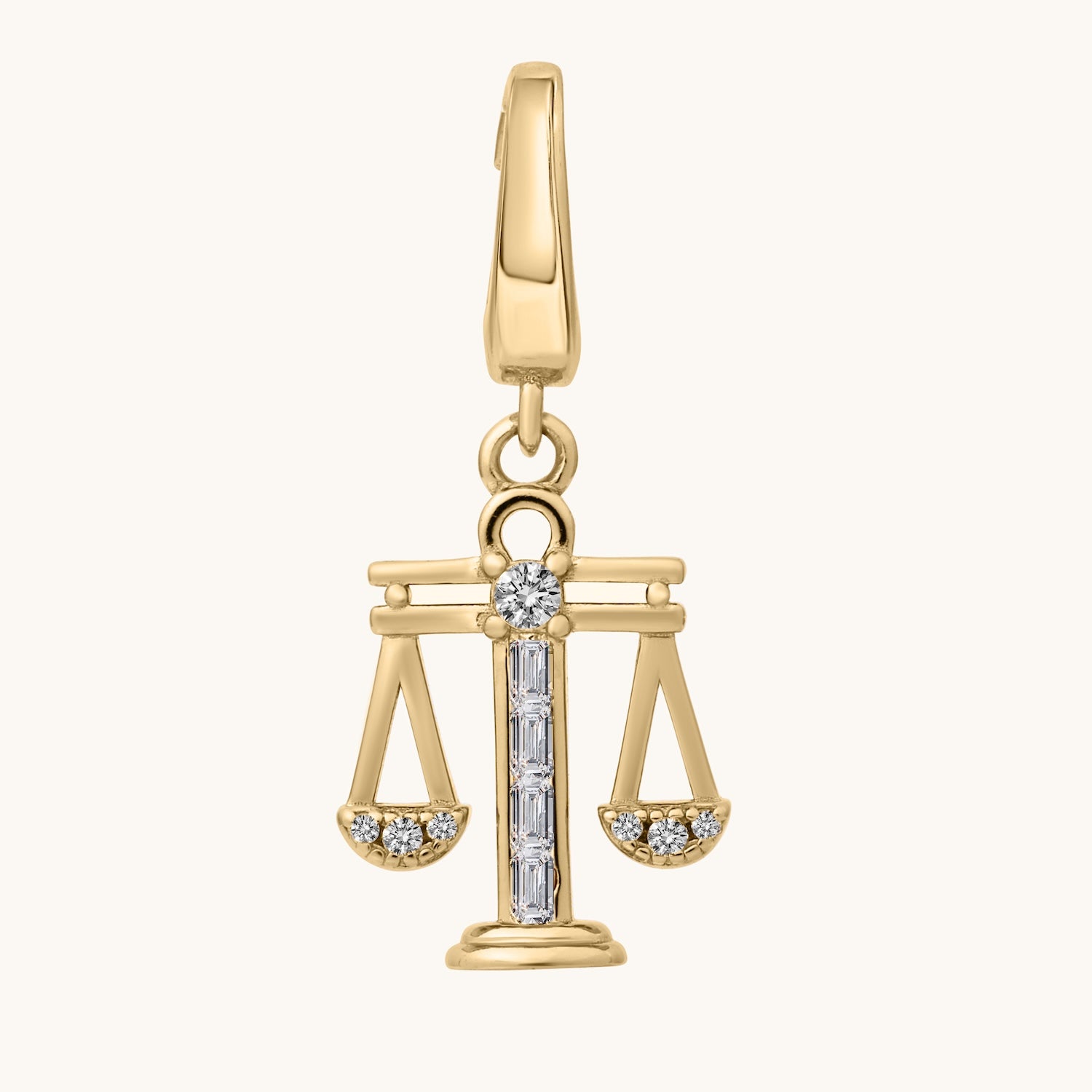 Gold pendant with a design resembling the scales of justice on a white background