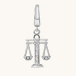 Silver pendant with a design resembling the scales of justice on a white background