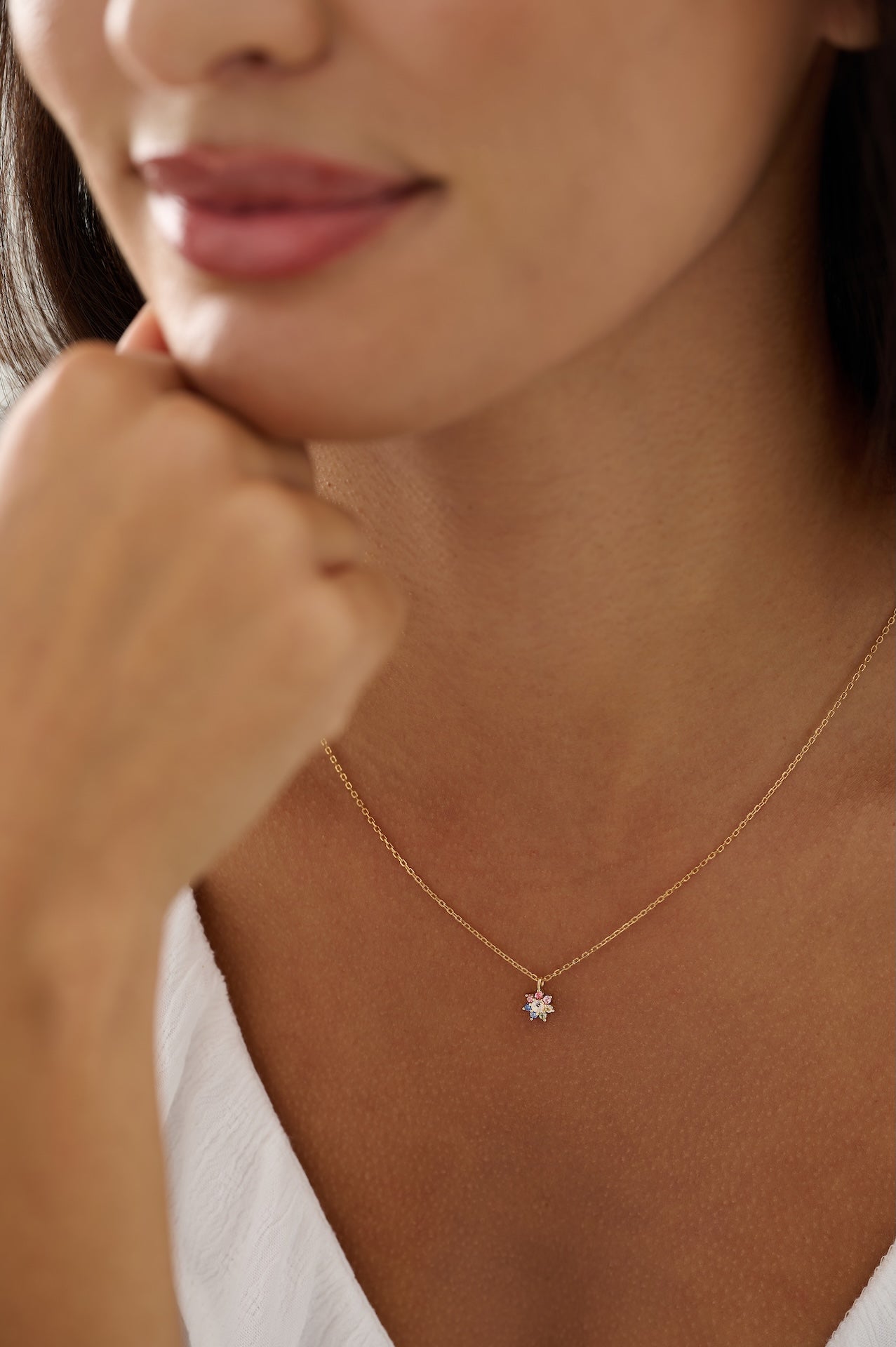 Close-up of a person wearing a delicate necklace with a small pendant.