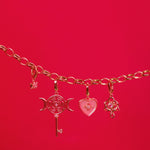 Gold bracelet with charms on a red background