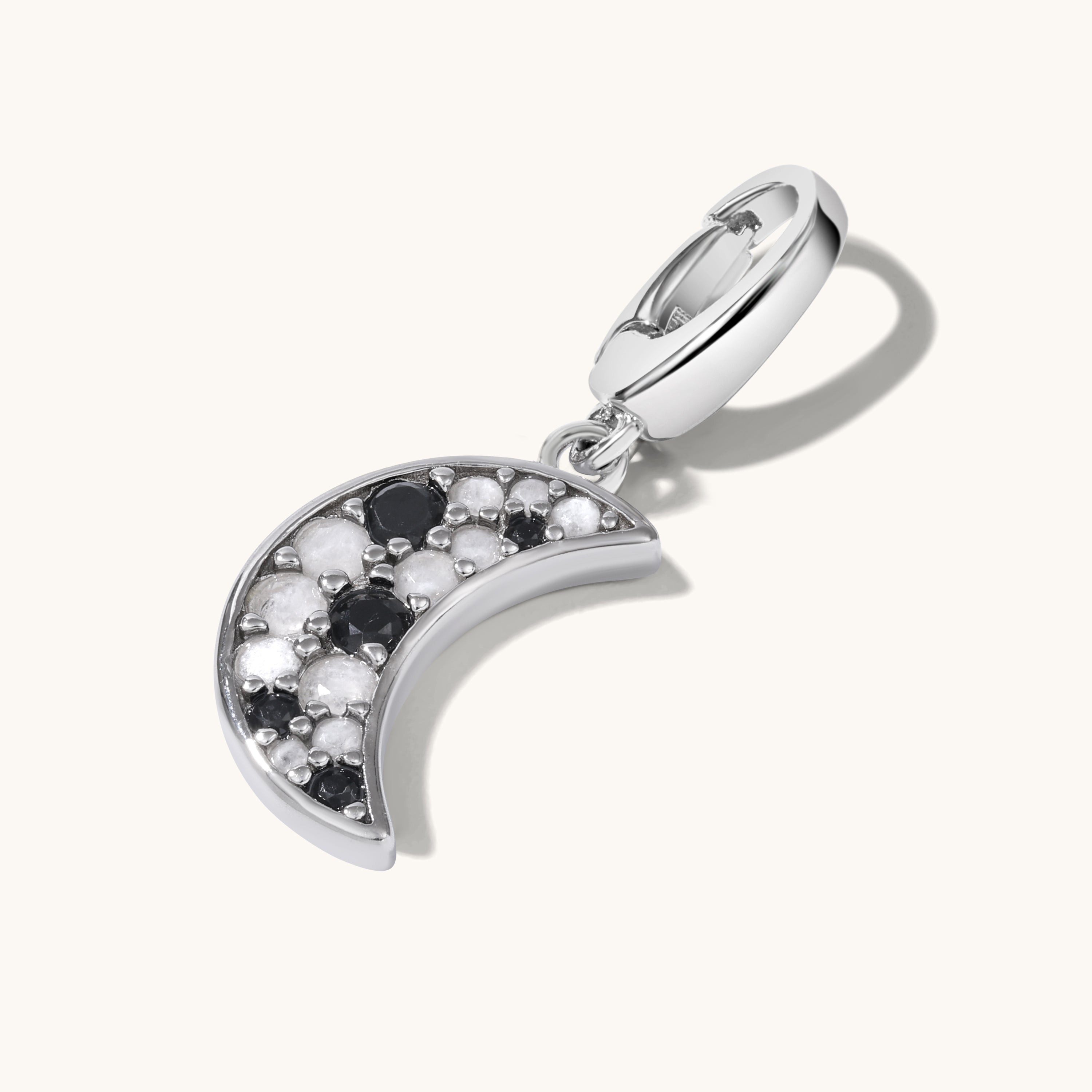 Silver crescent moon charm with clustered black and white gemstones