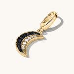 Gold crescent moon charm with black and white gemstone inlay.