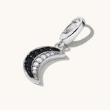 Silver crescent moon charm with black and white gemstone inlay.