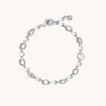 A silver-toned link bracelet featuring alternating polished oval links and smooth white bead links, displayed on a clean off-white background.