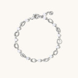 A silver-toned link bracelet featuring alternating polished oval links and smooth white bead links, displayed on a clean off-white background.