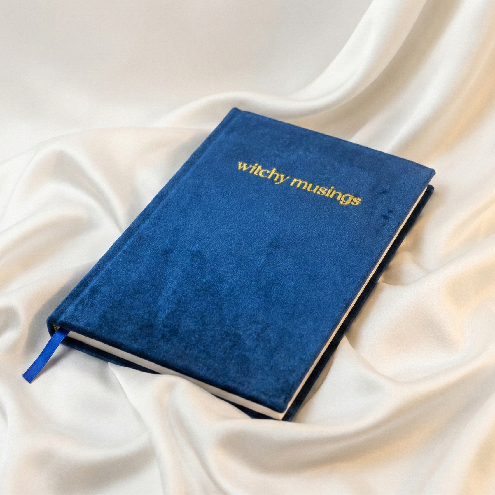 Navy blue notebook on white silky cloth