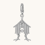A silver-toned house charm pendant with a small clear gemstone, shown on a plain off-white background.