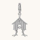 A silver-toned house charm pendant with a small clear gemstone, shown on a plain off-white background.