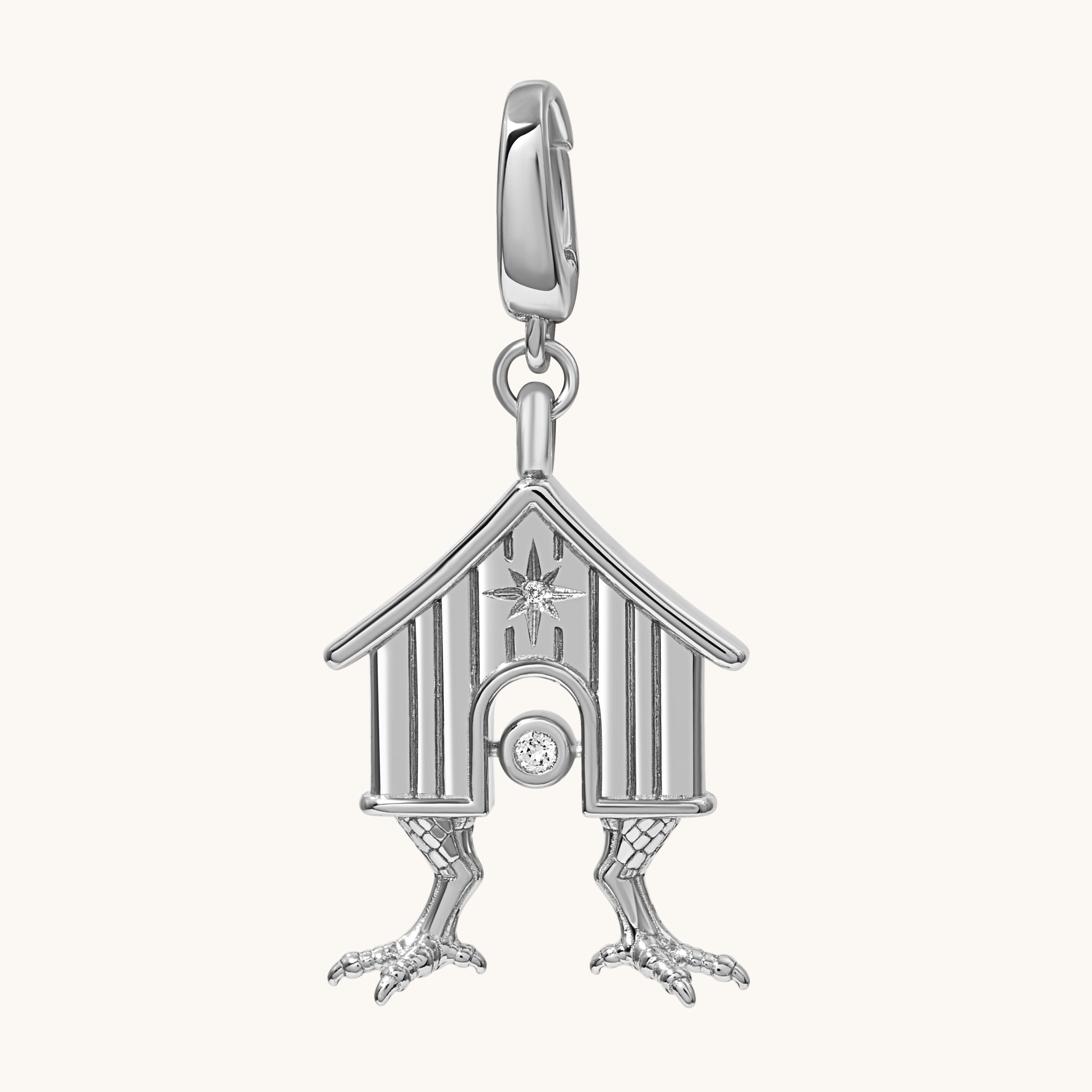 A silver-toned house charm pendant with a small clear gemstone, shown on a plain off-white background.