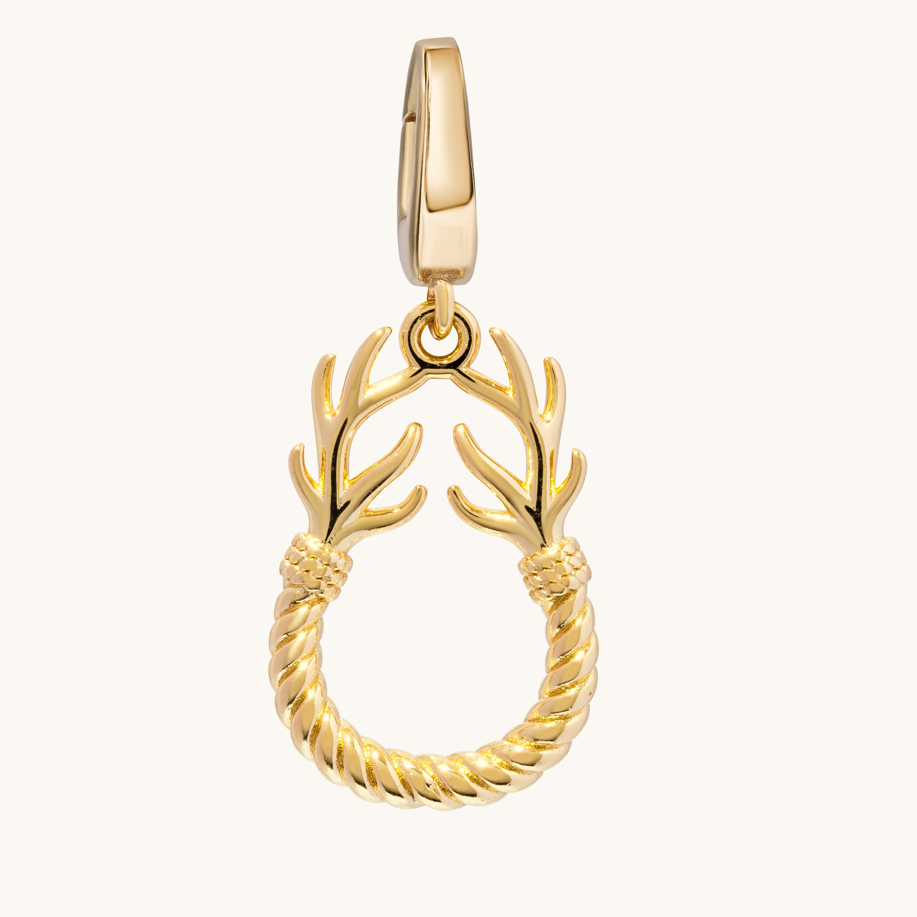 A gold charm featuring a rope-wrapped circular ring with antler-like branches extending from the top, shown on a plain off-white background.