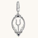 A silver-toned teardrop-shaped pendant charm featuring a central trident symbol, ornate filigree borders, and two small black gemstone accents, shown on a light cream background.