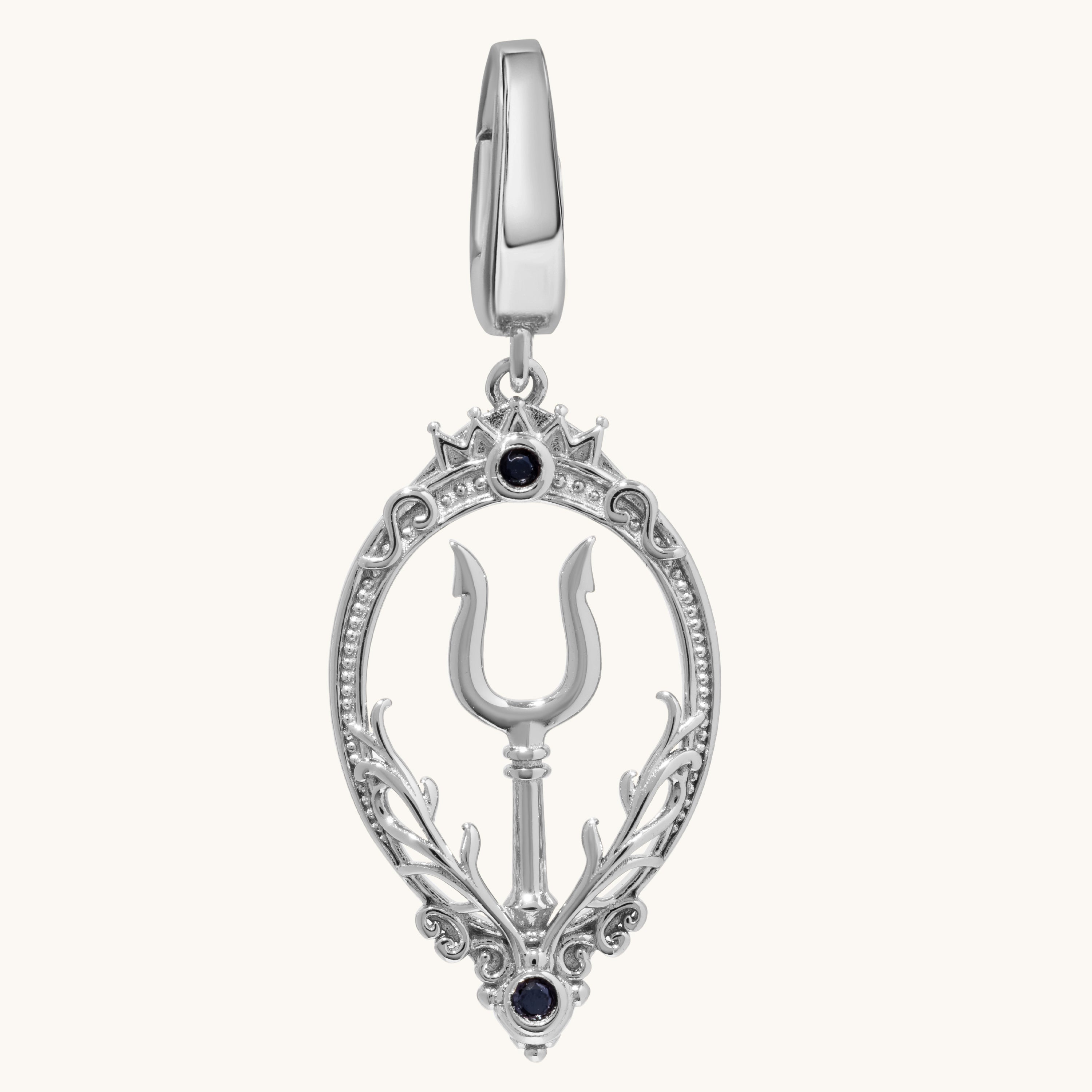 A silver-toned teardrop-shaped pendant charm featuring a central trident symbol, ornate filigree borders, and two small black gemstone accents, shown on a light cream background.