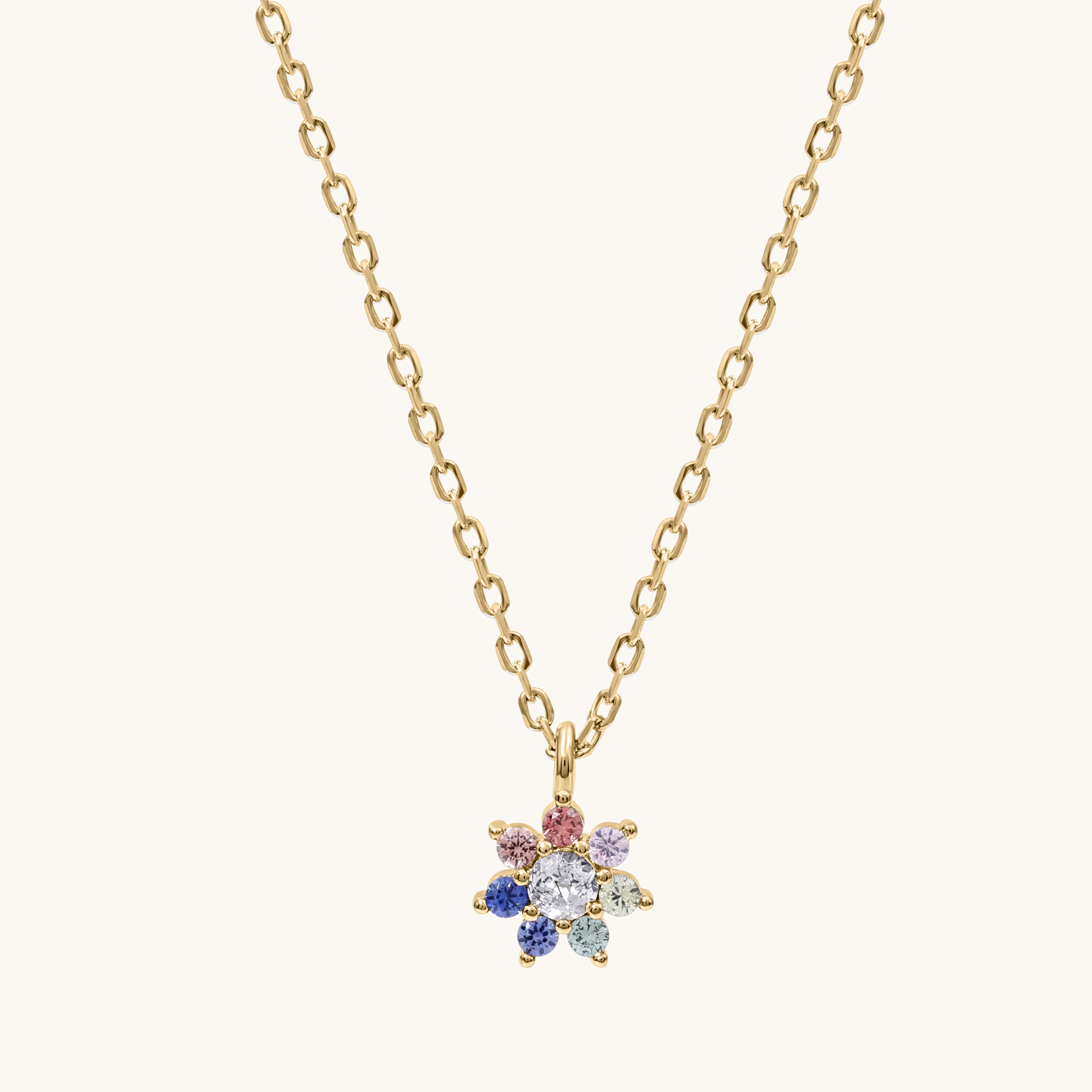 Gold necklace with a colorful flower-shaped pendant on a white background