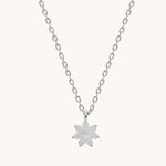 Silver necklace with a flower pendant on a white background