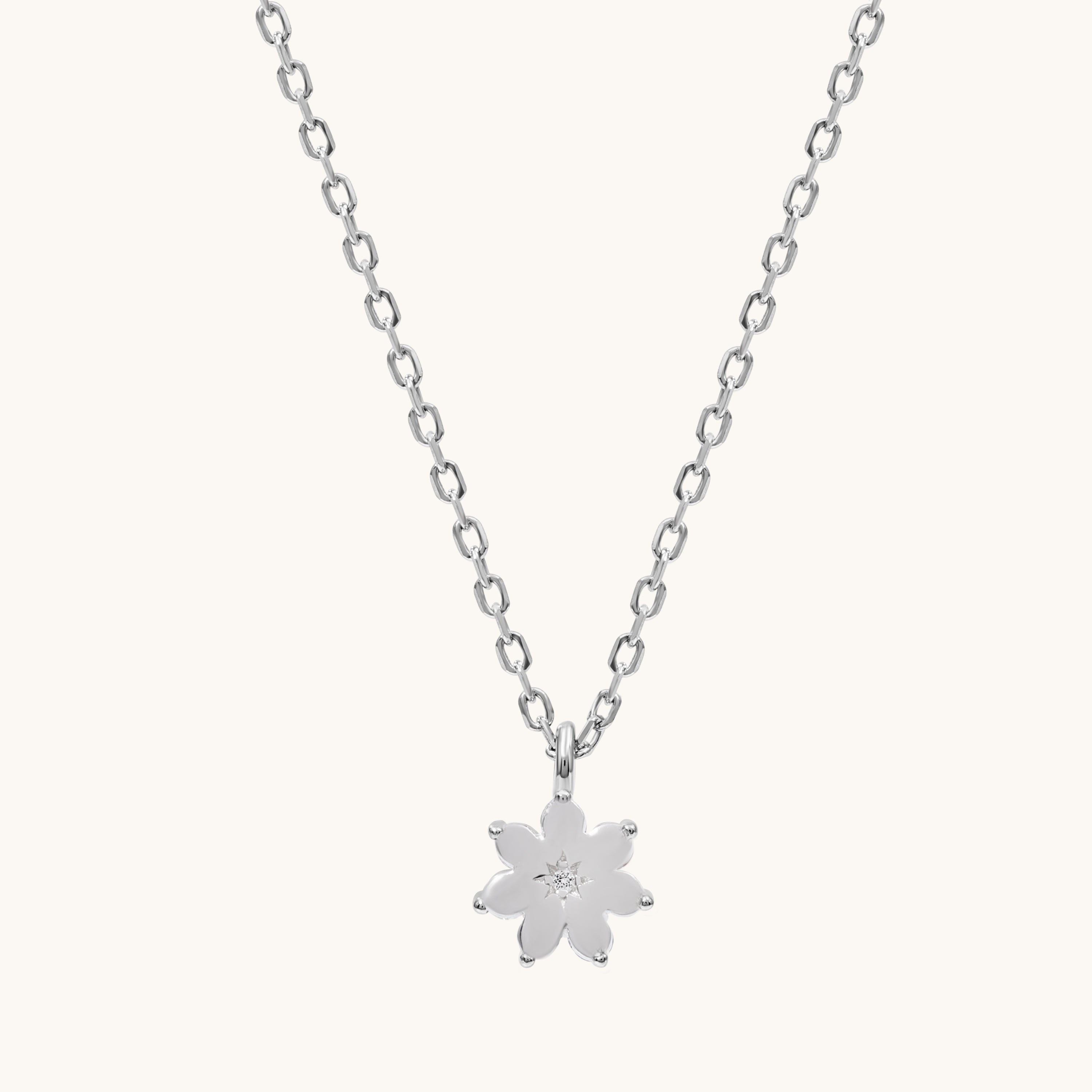 Silver necklace with a flower pendant on a white background